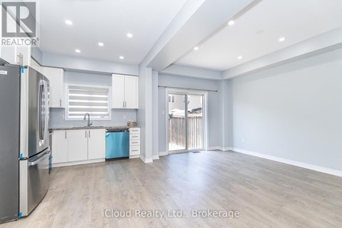 A spacious kitchen with white cabinets and a refrigerator.