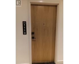 A brown door with a sign on the wall above it.