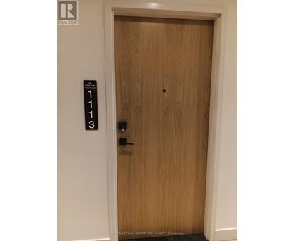 A brown door with a sign on the wall above it.