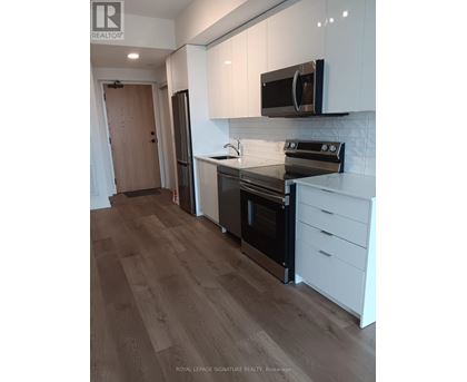 A kitchen with white cabinets and a black stove top oven.