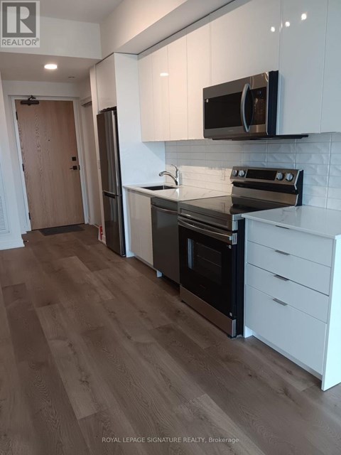 A kitchen with white cabinets and a black stove top oven.
