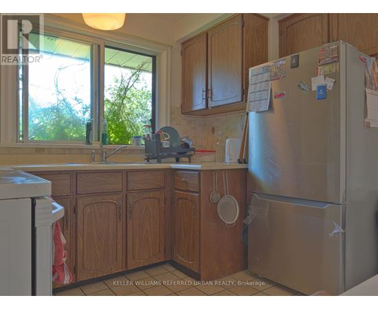 A kitchen with wooden cabinets and a refrigerator with magnets and notes on it.