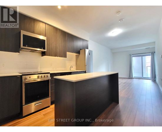 A kitchen with dark wood cabinets and stainless steel appliances.