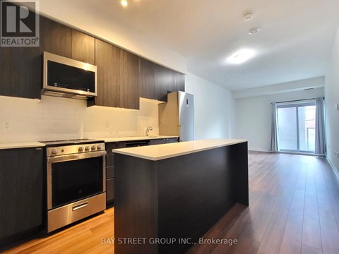 A kitchen with dark wood cabinets and stainless steel appliances.