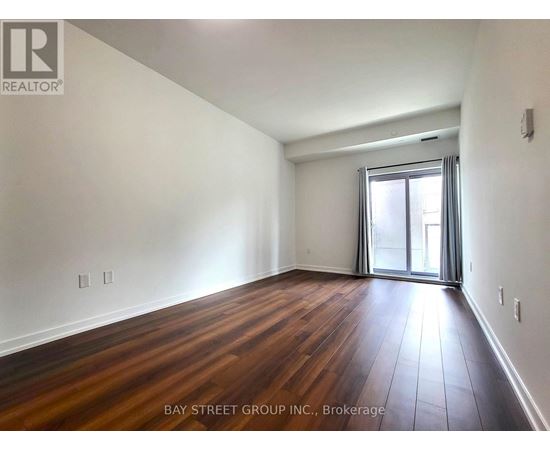 A room with wooden flooring and a sliding glass door.