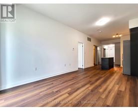 A spacious room with wooden floors and white walls.