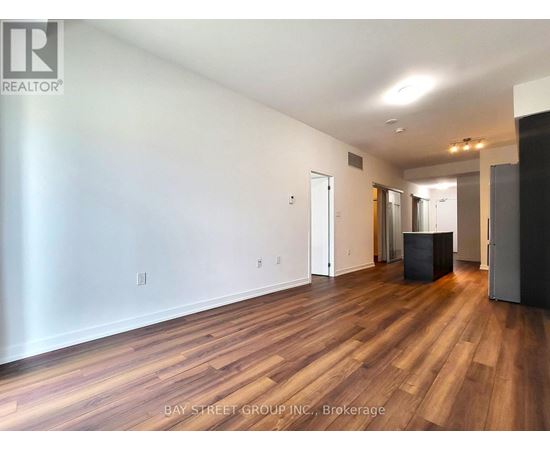 A spacious room with wooden floors and white walls.