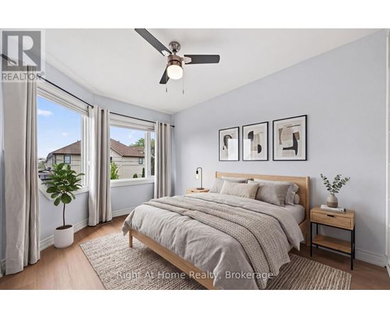 A bedroom with a bed, nightstand, and a ceiling fan.