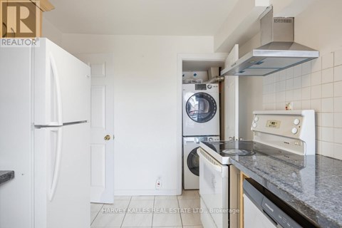 A kitchen with a white fridge, a washing machine, a dishwasher and a microwave.
