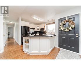 A kitchen with a black door and a wreath on it.