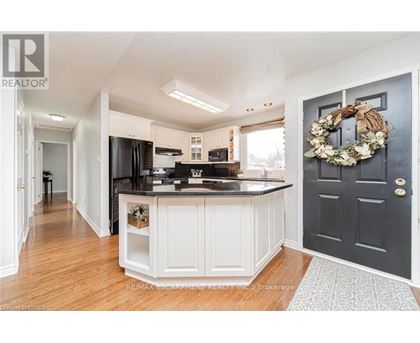 A kitchen with a black door and a wreath on it.