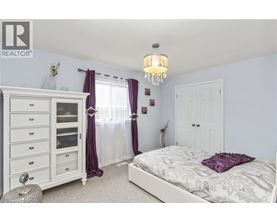 A bedroom with a white bed and a chandelier.