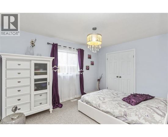 A bedroom with a white bed and a chandelier.