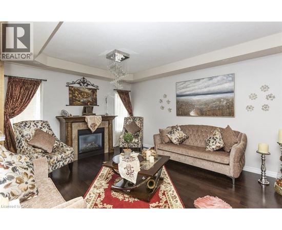 A living room with a fireplace and a painting on the wall.