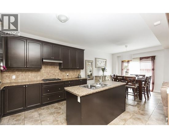 A kitchen with brown cabinets and a granite countertop.