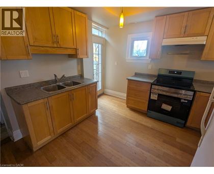A kitchen with wooden cabinets and a black dishwasher.