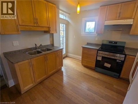 A kitchen with wooden cabinets and a black dishwasher.