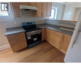 A kitchen with wooden cabinets and a black stove top oven.