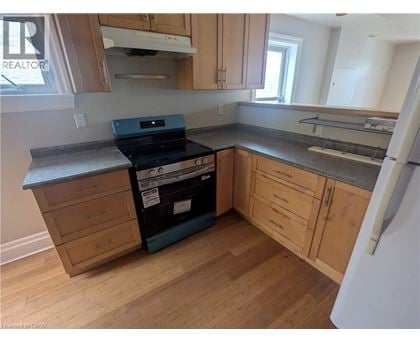 A kitchen with wooden cabinets and a black stove top oven.