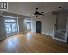 A room with a ceiling fan and wooden flooring.