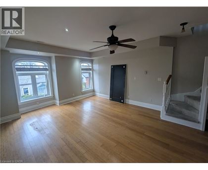 A room with a ceiling fan and wooden flooring.