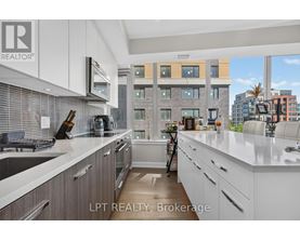 A modern kitchen with white cabinets and a view of the city.