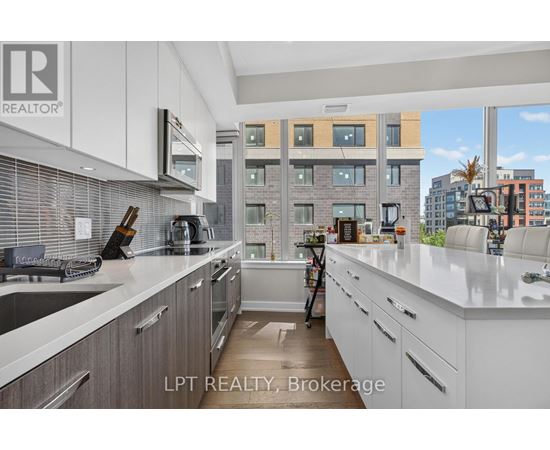 A modern kitchen with white cabinets and a view of the city.