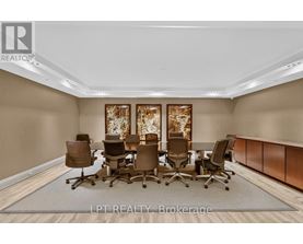 A conference room with brown chairs and a carpeted floor.