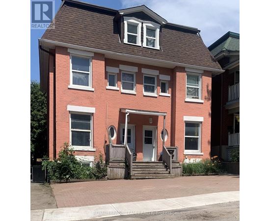 A red brick house with a white door and windows.