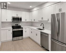 A kitchen with white cabinets and stainless steel appliances.