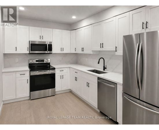 A kitchen with white cabinets and stainless steel appliances.