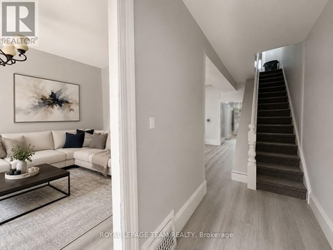 A living room with a couch, coffee table, and a painting on the wall.