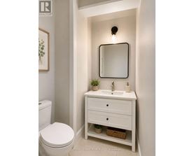 A white bathroom with a toilet, sink and mirror.