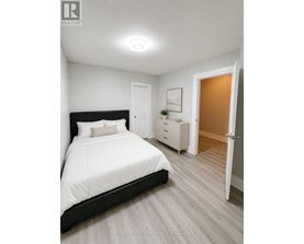 A bedroom with a large bed and a dresser.