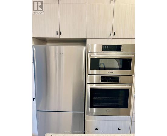 A stainless steel refrigerator and oven in a kitchen.