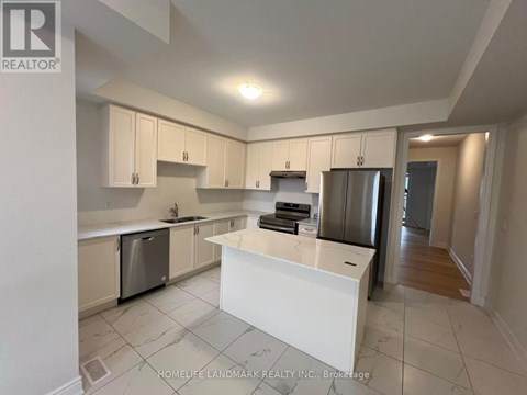 A kitchen with white cabinets and appliances.