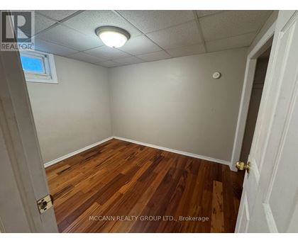 A room with wooden flooring and white walls.