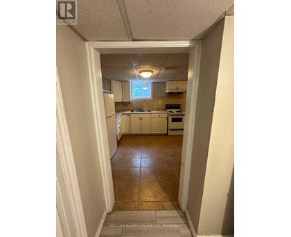 A kitchen with white cabinets and a tile floor.