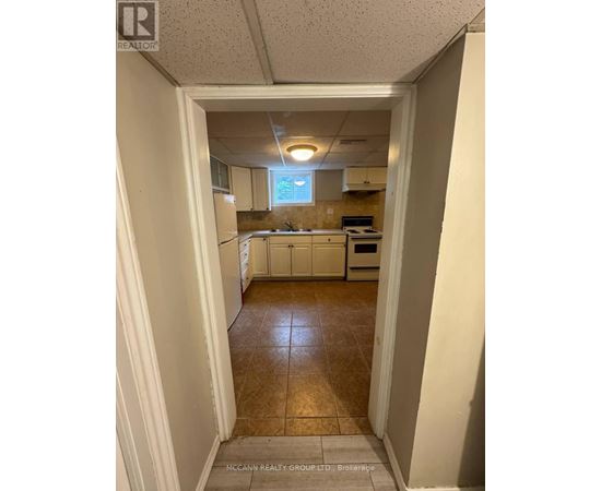 A kitchen with white cabinets and a tile floor.