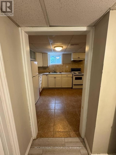 A kitchen with white cabinets and a tile floor.