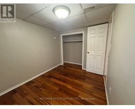 A room with wooden flooring and a white door.