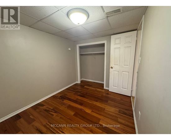 A room with wooden flooring and a white door.