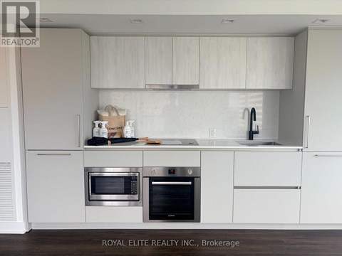 A modern kitchen with white cabinets and stainless steel appliances.