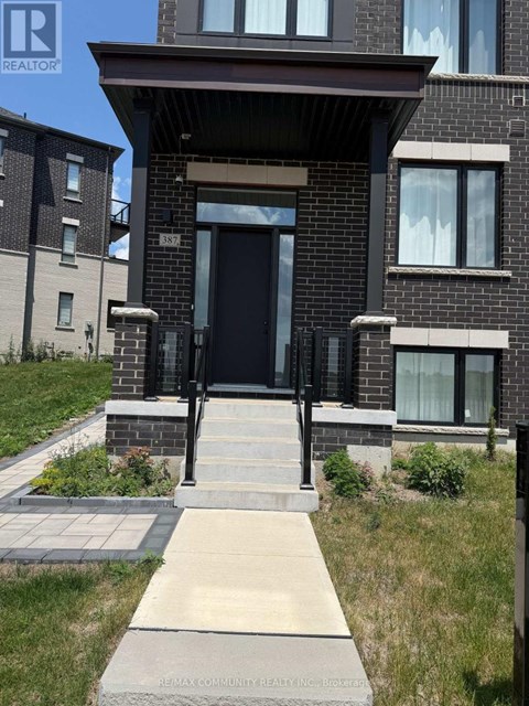 A brick house with a black front door and a small porch.