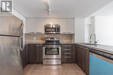 A kitchen with a stainless steel refrigerator, oven, and microwave.