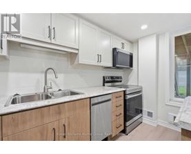 A kitchen with white cabinets and a stainless steel sink.