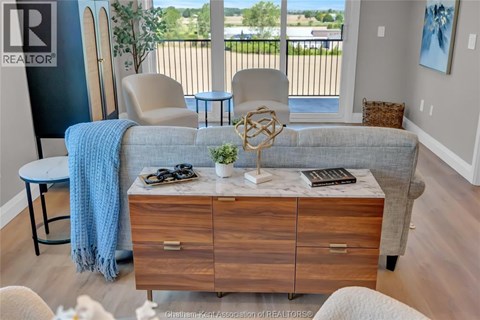 A living room with a couch, chair, and a table with a plant on it.
