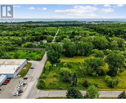 A bird's eye view of a green landscape with a building and cars.