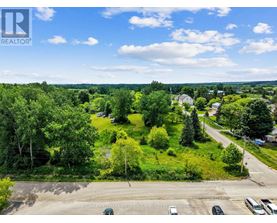 A bird's eye view of a residential area with houses, trees, and a parking lot.