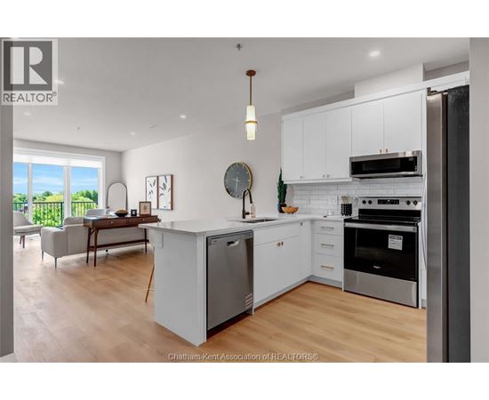 A modern kitchen with white cabinets and stainless steel appliances.
